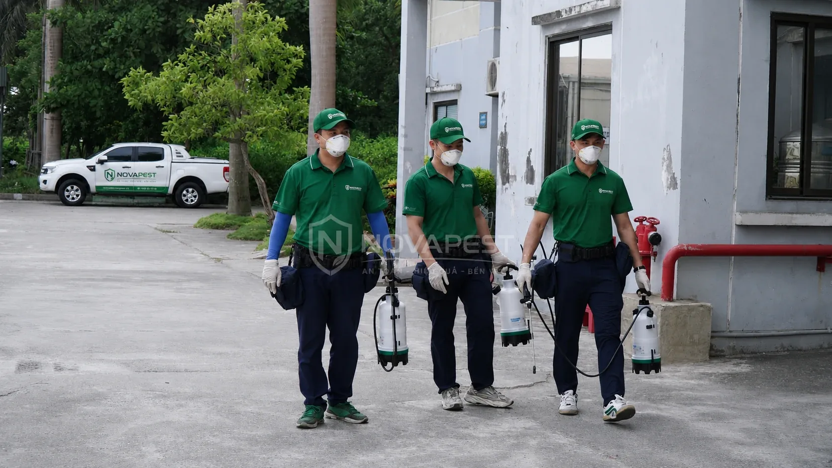 Ba kỹ thuật viên NOVAPEST mang thiết bị kiểm soát sinh vật gây hại tại khu vực triển khai dịch vụ